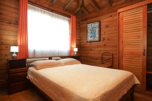 a bedroom with a bed and a window in a cabin at Casa Marcellino Lodge in Cahuita