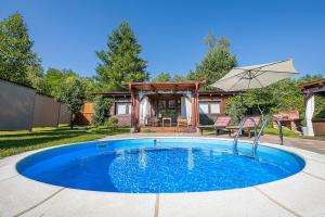 a swimming pool in the yard of a house at Holiday Home Arcadia with pool, hot tub and sauna in Pleškovec