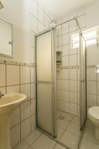 uma casa de banho com um chuveiro, um lavatório e um WC. em Casa 150m da praia em pátio familiar em Florianópolis