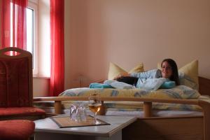 Una mujer acostada en una cama en una habitación en Hasseröder Hof, en Wernigerode