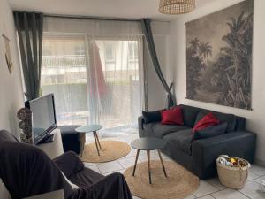 a living room with a couch and a tv at Appartement terrasse privée grande plage à 100 m - Parking gratuit in Saint-Cast-le-Guildo
