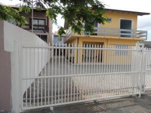 een wit hek voor een huis bij Casa 150m da praia em pátio familiar in Florianópolis
