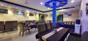 a restaurant with tables and chairs and a blue pole at Hotel Amritsar Inn in Amritsar