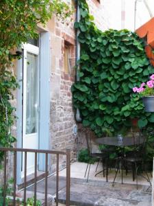 una parete verde sul lato di un edificio con tavolo di Villa des Capucins a Luxeuil-les-Bains