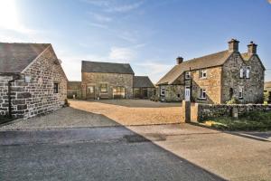an old stone house with a driveway in front of it at Moorland View Farm B&B in Oakamoor