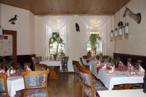 un comedor con mesas y sillas blancas en Hasseröder Hof, en Wernigerode