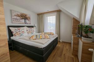 a bedroom with a bed and a window at Ferienhaus Holzer in Egg am Faaker See