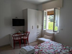 1 dormitorio con cama, mesa y ventana en Al Pozzo en Negrar