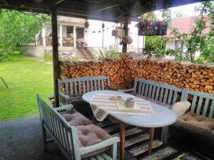 a table and chairs on a patio with a pile of logs at Vahtra Vacation House in Käsmu