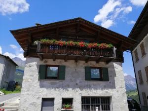 un edificio con un balcón con flores. en Casa Laura en Valdidentro