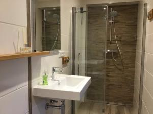 a bathroom with a sink and a shower at Appartement B&B De Koning in Afferden
