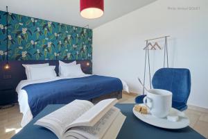 een slaapkamer met een bed met een boek en een kopje koffie bij B&B Maison Ruthier in Waimes