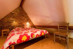 - une chambre mansardée avec un lit et deux chaises dans l'établissement Holiday Home Het Verloren Goed, à Wingene
