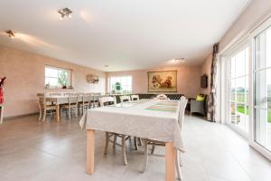 - une salle à manger avec une table, des chaises et des fenêtres dans l'établissement Holiday Home Het Verloren Goed, à Wingene