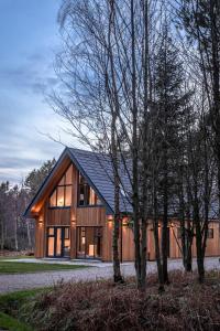 una casa con techo negro y algunos árboles en Newlands Lodges, en Shotley Bridge