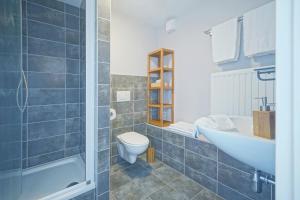 een badkamer met een bad, een toilet en een wastafel bij B&B Maison Ruthier in Waimes