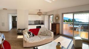 sala de estar con sofá y cocina en Superbe 2P vue mer, ensoleillé, piscine en Roquebrune-Cap-Martin