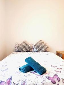 a bed with a blue pillow and butterflies on it at Waterloo Rooms in London