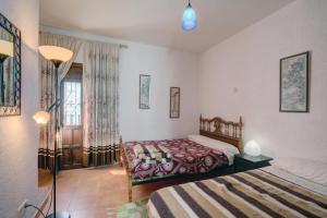 a bedroom with two beds and a window at La Casa del Bandolero in Júzcar