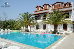 a hotel with a swimming pool in front of a building at Captains Studios & Apartments in Kavos