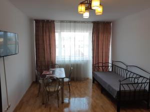 1 dormitorio con cama, mesa y ventana en Maria Terezia Residence, en Sibiu