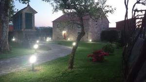 a large stone building with lights in the yard at Torres de Moreda in A Estrada