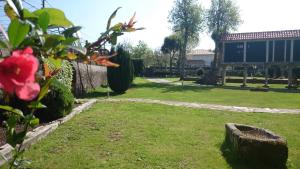 a garden with a red flower in the grass at Torres de Moreda in A Estrada