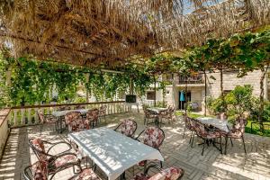 an outdoor patio with tables and chairs and vines at Apartments Bonaca in Igalo