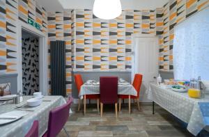 un comedor con 2 mesas y una pared estampada en Kingsley Guest House, en Edimburgo