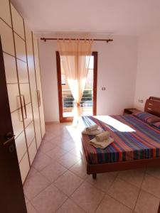 a bedroom with a bed and a window at Da.Da. House in La Maddalena