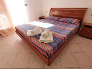 a bedroom with a bed with towels on it at Da.Da. House in La Maddalena