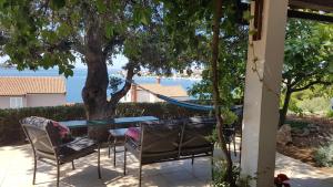 eine Terrasse mit einem Tisch, Stühlen und einer Hängematte in der Unterkunft Studio apartman Terrace-Sevid in Sevid