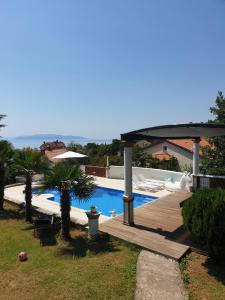 a villa with a swimming pool and a wooden deck at Pobri in Matulji