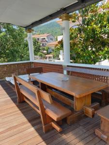 a wooden table and benches on a wooden deck at Pobri in Matulji