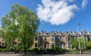 um grande edifício com uma árvore em frente em Kingsley Guest House em Edimburgo