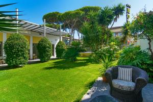 a garden with two chairs and a lawn at Hotel Spinelli in Viareggio