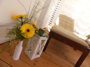 a vase with flowers in a room with a chair at Blue Wave Mobile Home in Biograd na Moru
