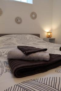 una pila de toallas sentadas encima de una cama en Clermont Centre- Appartement Privé en Clermont