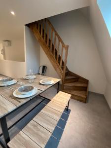een eetkamer met een tafel en een trap bij Le Duplex St Nicolas in Beaune
