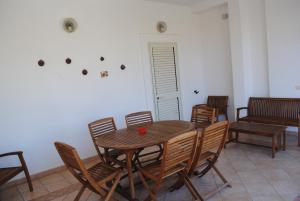 a dining room with a wooden table and chairs at Summer Beach Rooms in Fontane Bianche