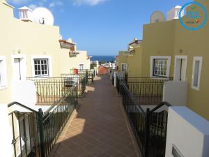 einen Gang zwischen zwei Gebäuden mit einem Zaun in der Unterkunft Apartamento T1 com vista mar perto da Praia N.ª Sra. da Rocha in Porches