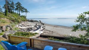 a sandy beach with blue chairs and the ocean at Parker by the Sea in Victoria