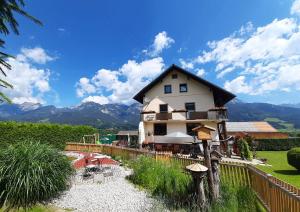 a house on a hill with mountains in the background at Appartment LuKi in Haus im Ennstal