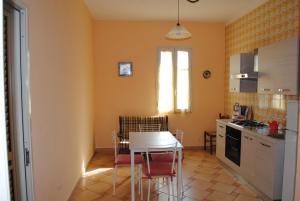 a kitchen with a table and chairs in a room at Summer Beach Rooms in Fontane Bianche