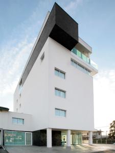 a white building with a black roof at Le Nove Hotel in Nove