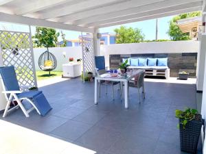 eine Terrasse mit einem weißen Tisch und Stühlen in der Unterkunft Villa White Sicilia in Santa Maria Del Focallo
