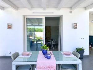 ein Esszimmer mit einem blauen Tisch und Stühlen in der Unterkunft Villa White Sicilia in Santa Maria Del Focallo