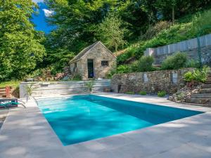 a swimming pool in a backyard with a stone house at Charming, cosy renovated farm in Les Houches in Verviers