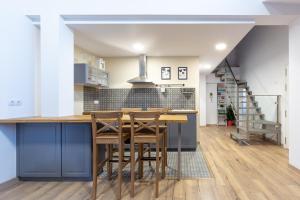 a kitchen with blue cabinets and a table with stools at Apartamentos Moreira & Betanzos in Betanzos