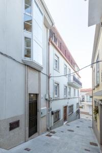 een leeg steegje met een wit gebouw bij Apartamentos Moreira & Betanzos in Betanzos